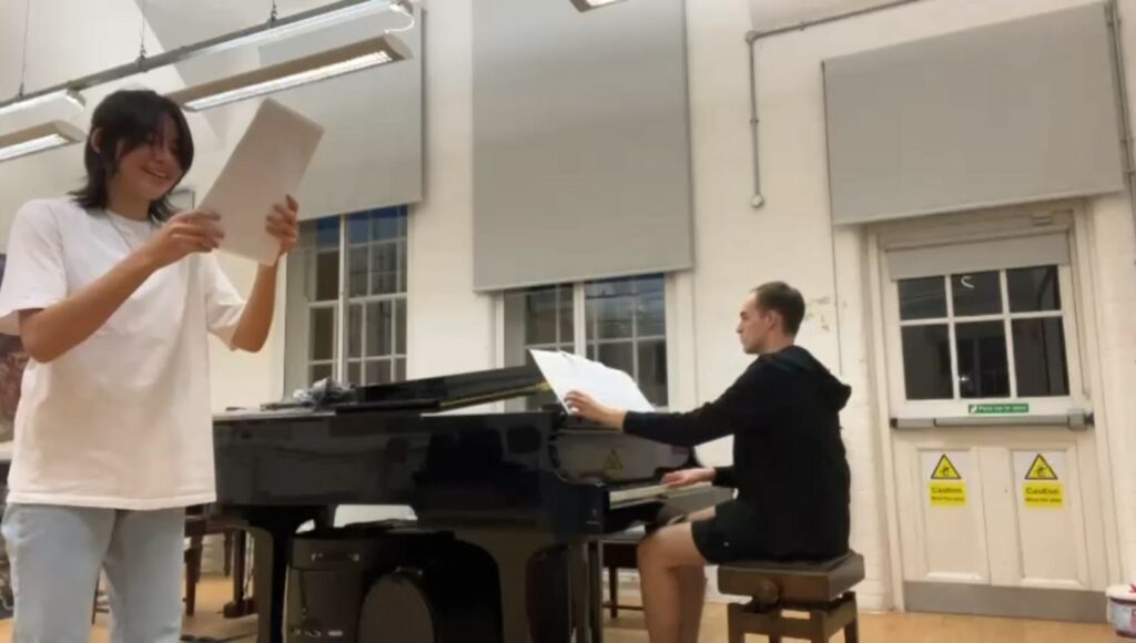 Niklas playing the piano with another person singing